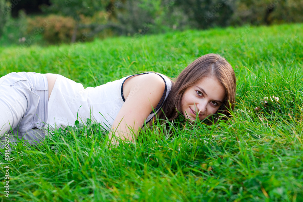 beautiful young woman lying on green grass beautiful young woman lying on green grass