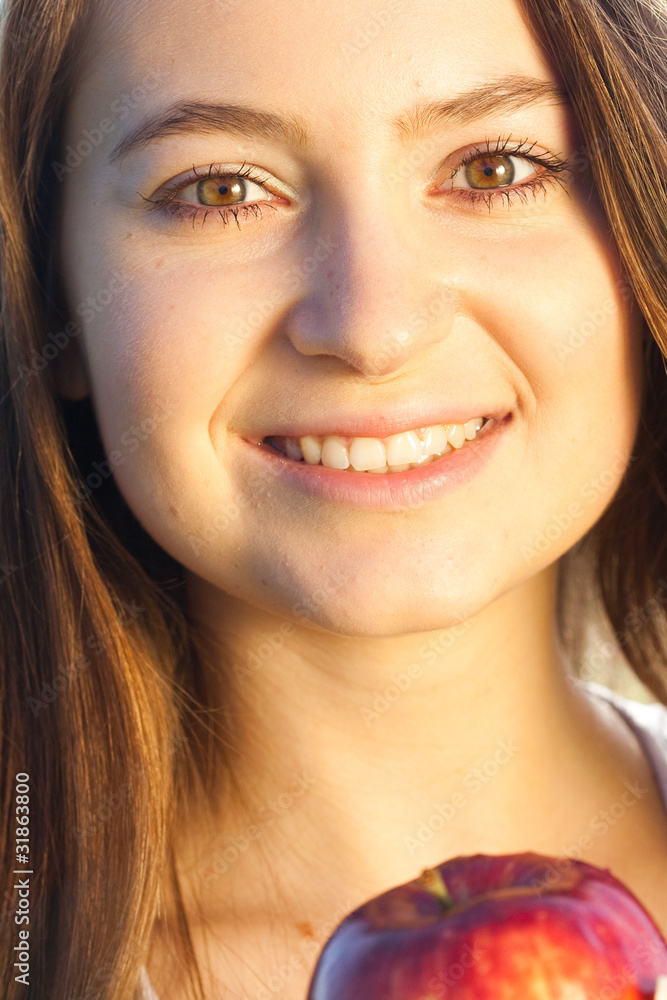 Obraz premium portrait of a beautiful young woman with apple outdoor