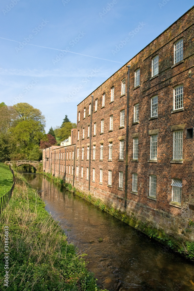 Old cotton mill beside river - vertical composition Old cotton mill beside river - vertical composition