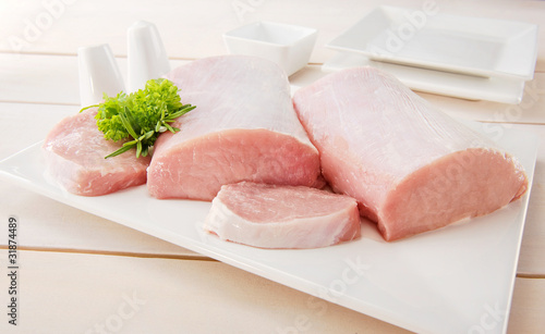 Raw pork chop with tableware photo