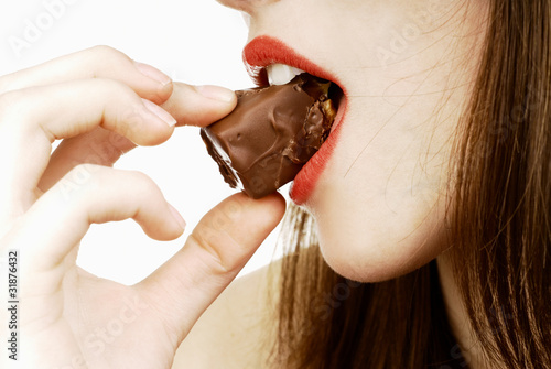 close up of woman's lips biting a chocolate bar