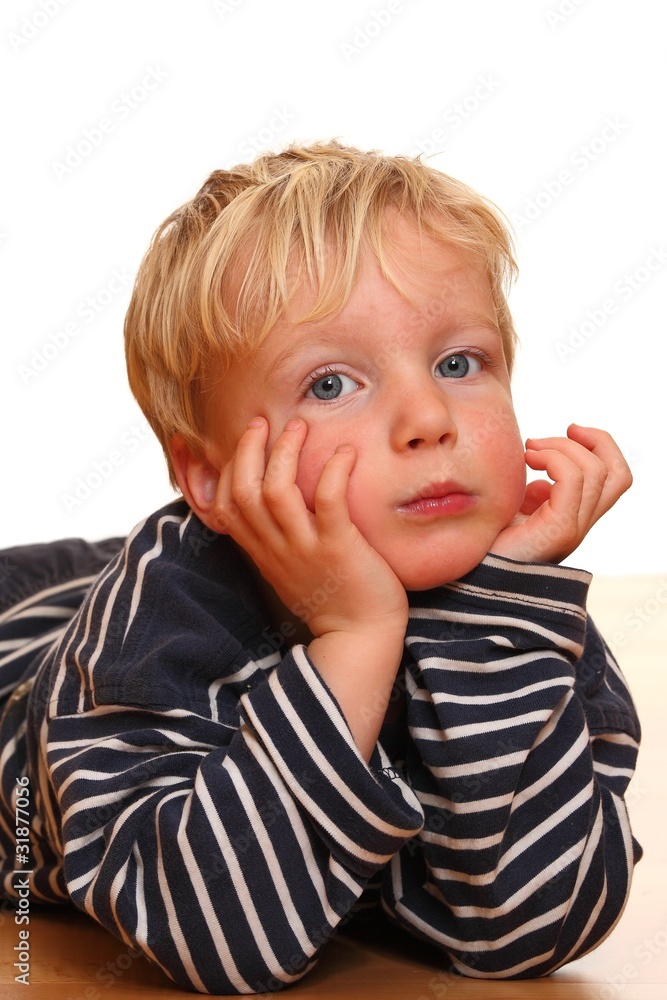 Porträt eines auf dem Boden liegenden Jungens Porträt eines auf dem Boden liegenden Jungens