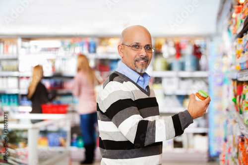 Vászonkép Smiling mature man shopping in the supermarket