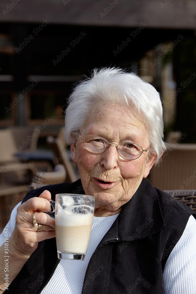 Nette alte Dame Portrait im Cafe trinkend Nette alte Dame Portrait im Cafe trinkend