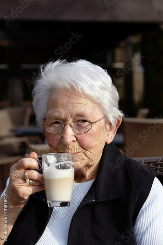 Nette alte Dame Portrait im Cafe trinkend
