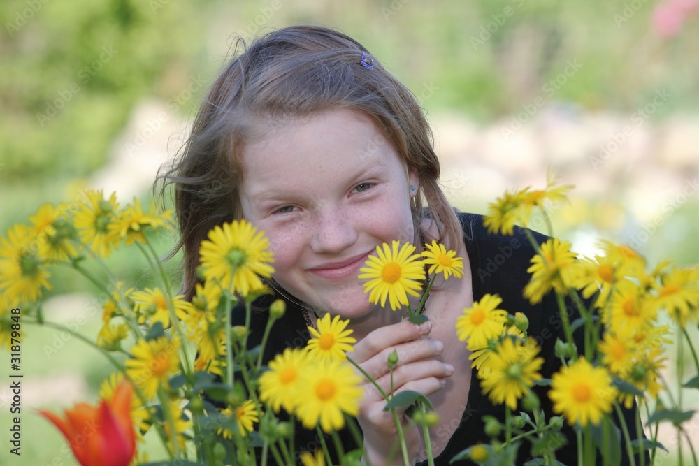 Junges Mädchen im Garten mit Blumen Junges Mädchen im Garten mit Blumen