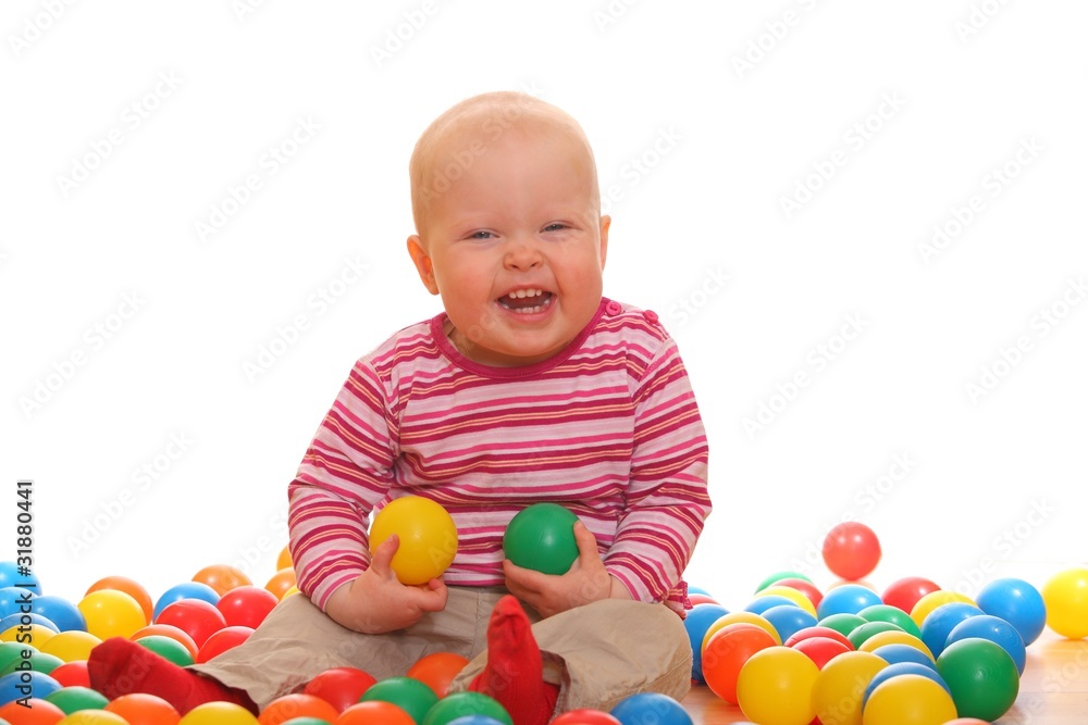 Kleinkind spielt mit bunten Bällen Kleinkind spielt mit bunten Bällen