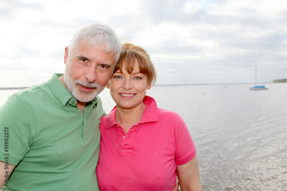 Portrait of senior couple standing by a lake