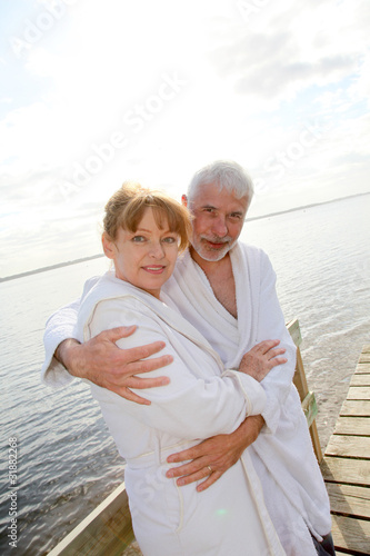 Senior couple in bathrobe standing on a pontoon