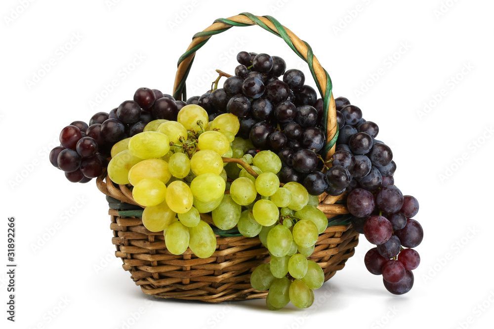 Clusters of yellow and black grapes in a basket on a white backg