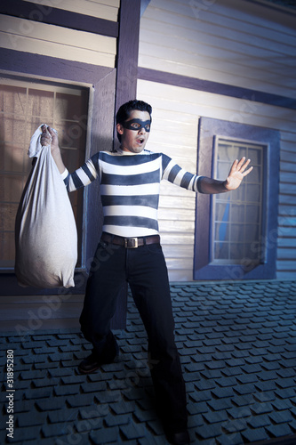 Canvas Print Thief on the roof getting caught by the police