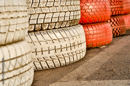 close up of racetrack fence of white and red of old tires