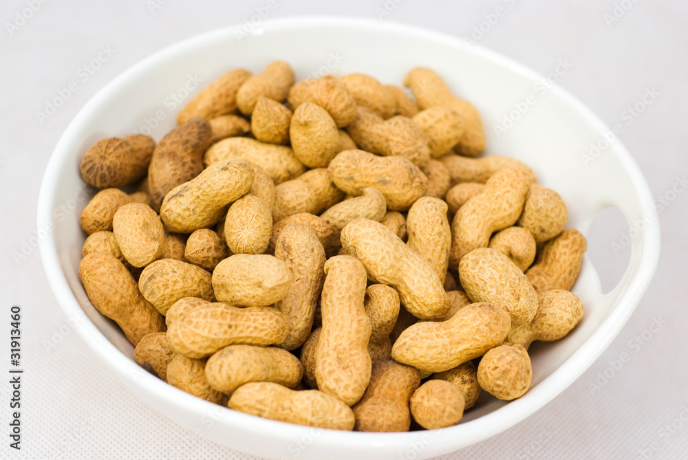 Pile of ripe crude peanuts in white bowl Pile of ripe crude peanuts in white bowl