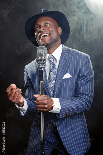Photography Black man with blue striped suit and blue hat singing.