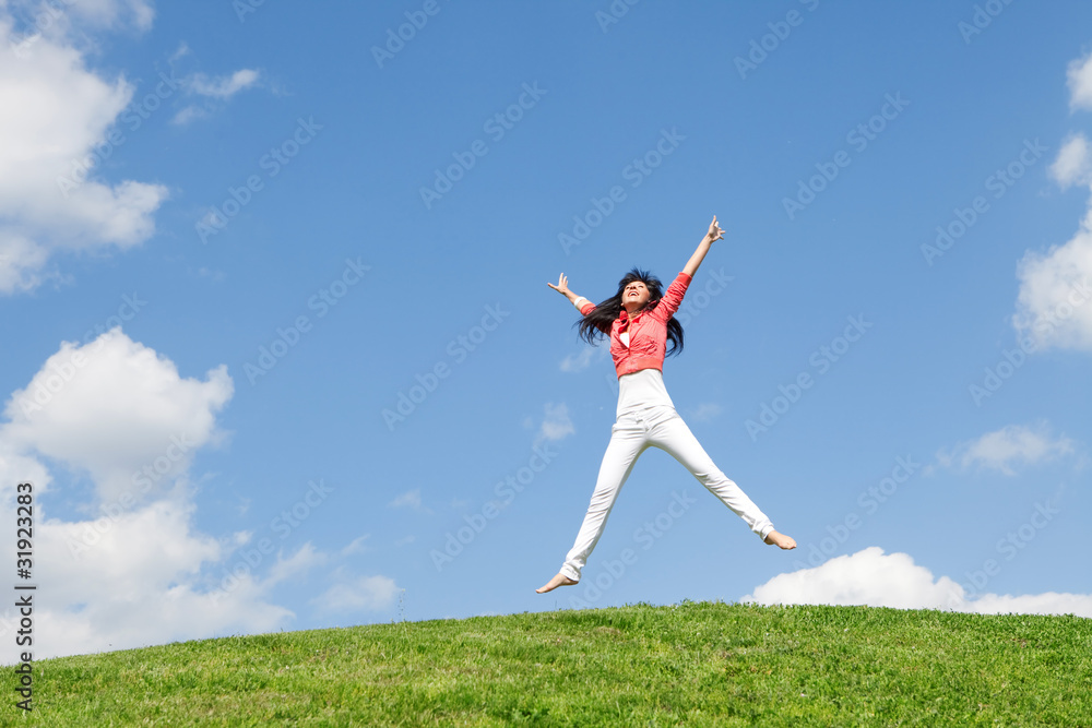 pretty young woman jumping on green grass pretty young woman jumping on green grass