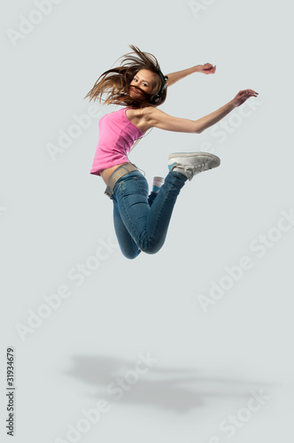 girl in headphones jumps