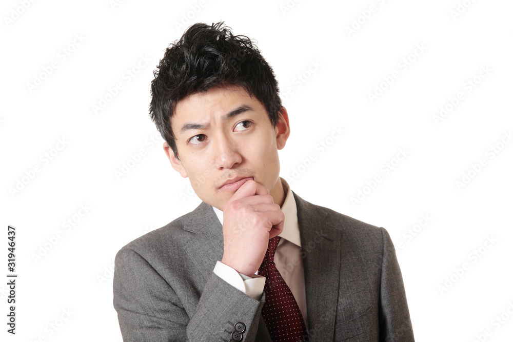 顎に手を置いて考えるスーツの男性 Stock Photo Adobe Stock