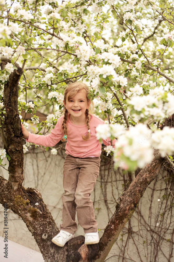 Mädchen steht im Apfelbaum und freut sich Mädchen steht im Apfelbaum und freut sich