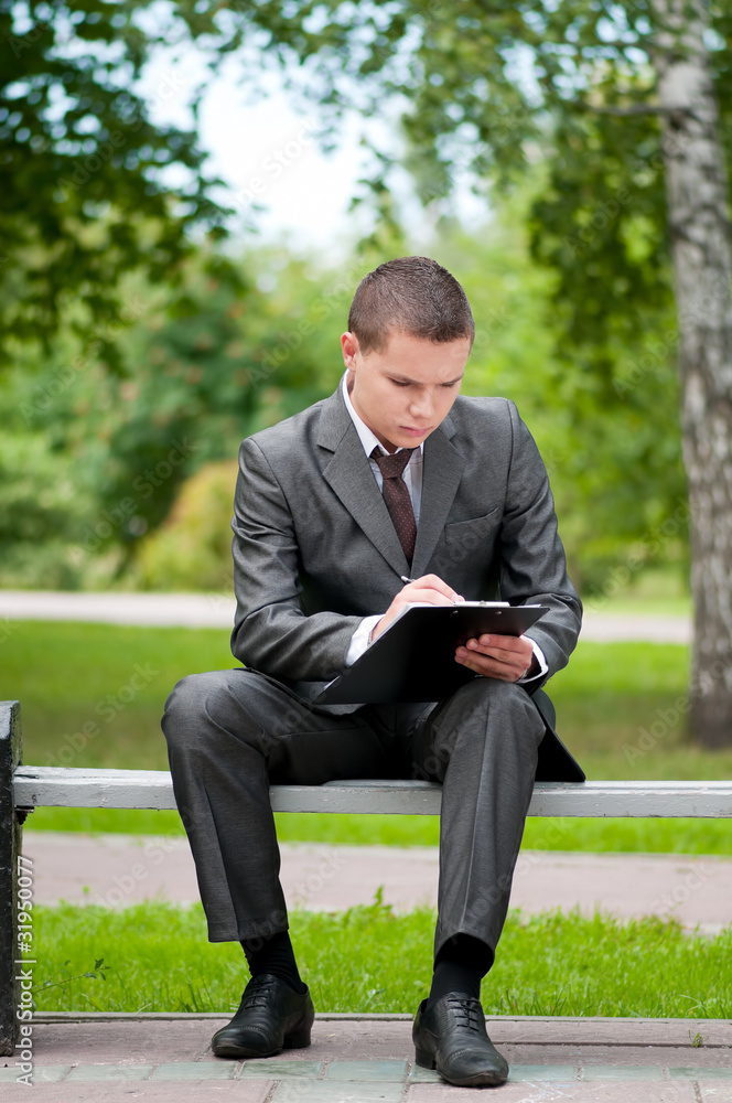 business man working with papers at park. Student business man working with papers at park. Student
