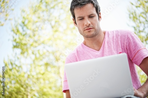 Handsome man with laptop outdoors © Nejron Photo