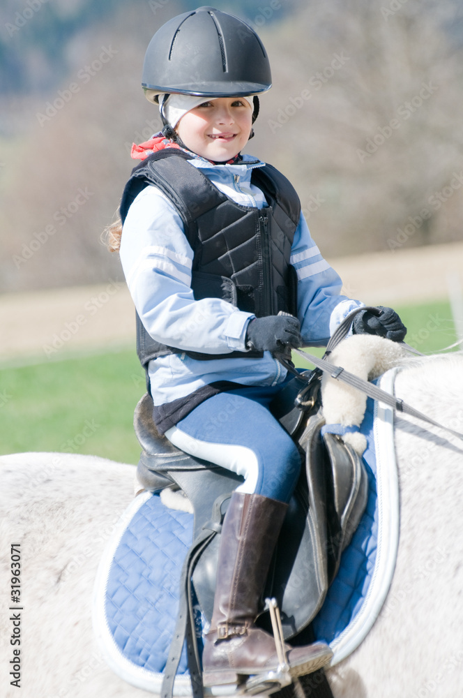 Obraz premium Horse riding - little girl is riding a horse