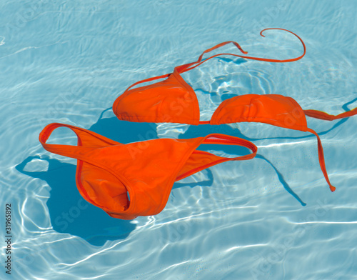 Obraz na plátně Orange bikini in clean water. Swim suit in turquoise pool.
