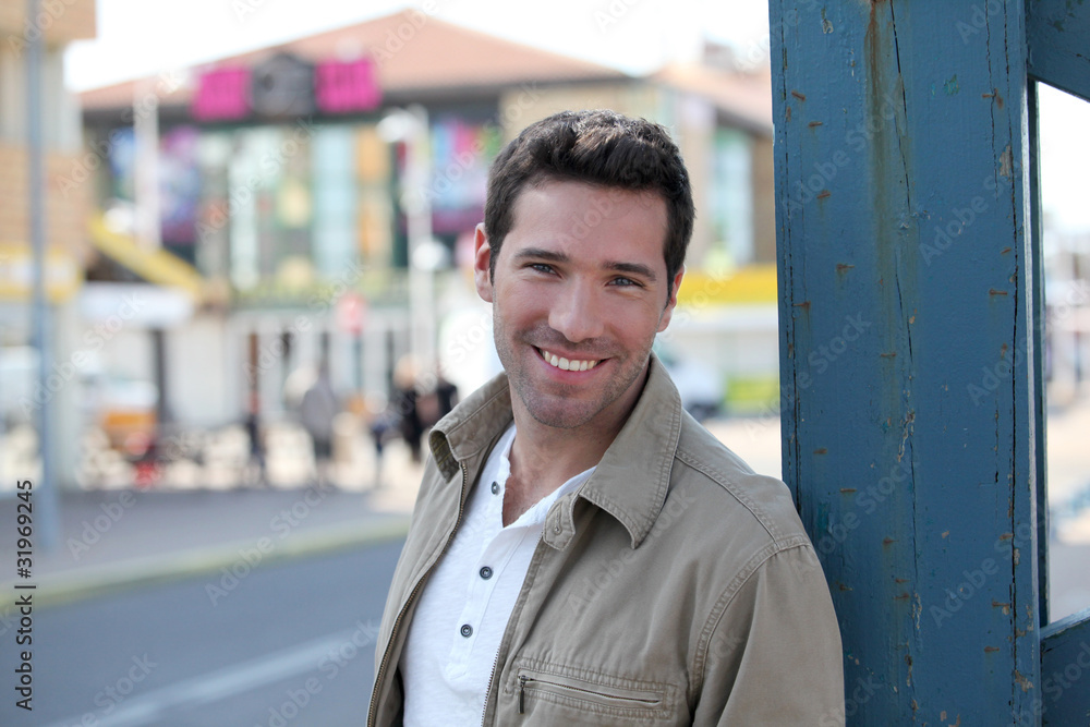 Fototapeta premium Portrait of handsome man standing in town