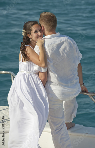 Newly married couple stood on the bow of a boat © Paul Vinten