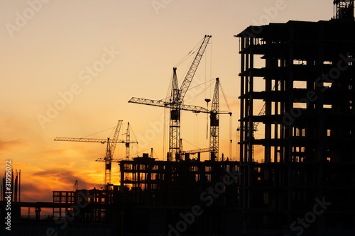 Фотография construction site with construction cranes at sunset