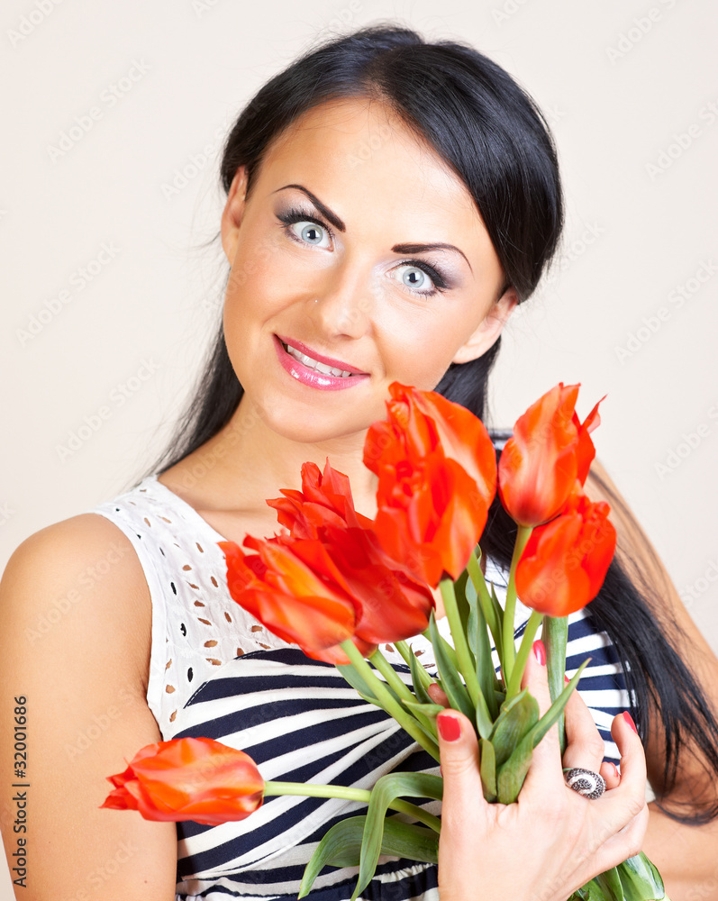Portrait of a woman with red flowers, studio shot Portrait of a woman with red flowers, studio shot