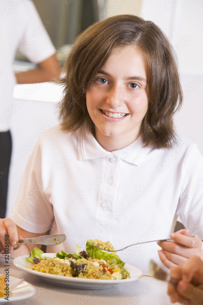 Schoolgirl enjoying her lunch in a school cafeteria