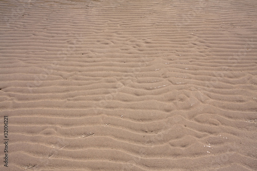 Sand background texture trough the ripple sea water