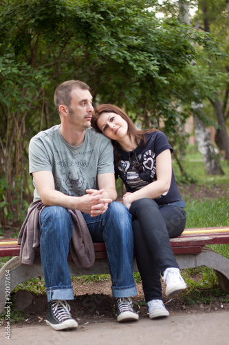 Young couple sitting on beanch in park