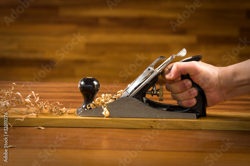 Bild auf Leinwand Hand of a carpenter using wood plane.
