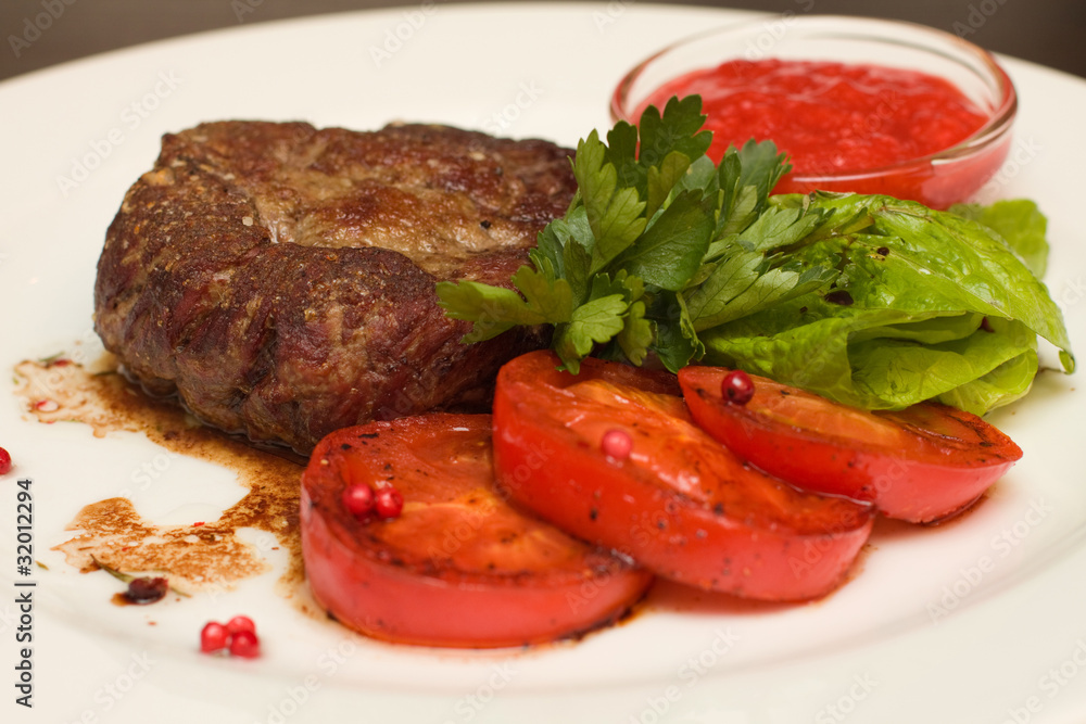 Grilled steak with garnish - closeup