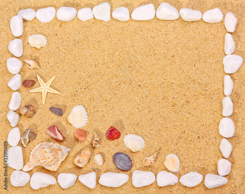 Sea shells and stones frame on sand