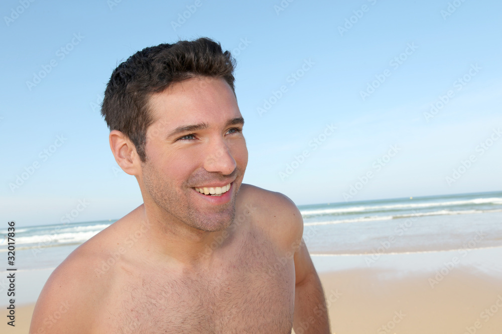 Smiling man jogging on a sandy beach Smiling man jogging on a sandy beach