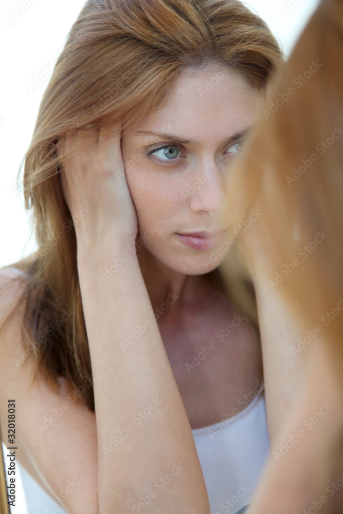 Fototapeta premium Beautiful woman looking in a mirror