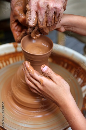 craftsman potter hands of teacher and pupil clay pottery