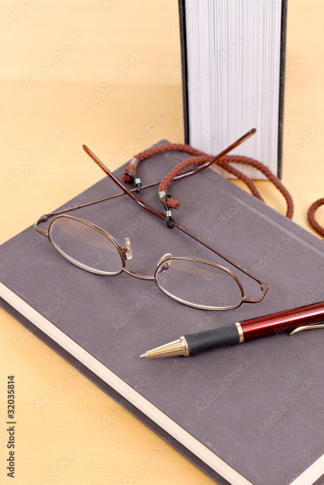 Fototapeta premium Reading Glasses and Pen on Book
