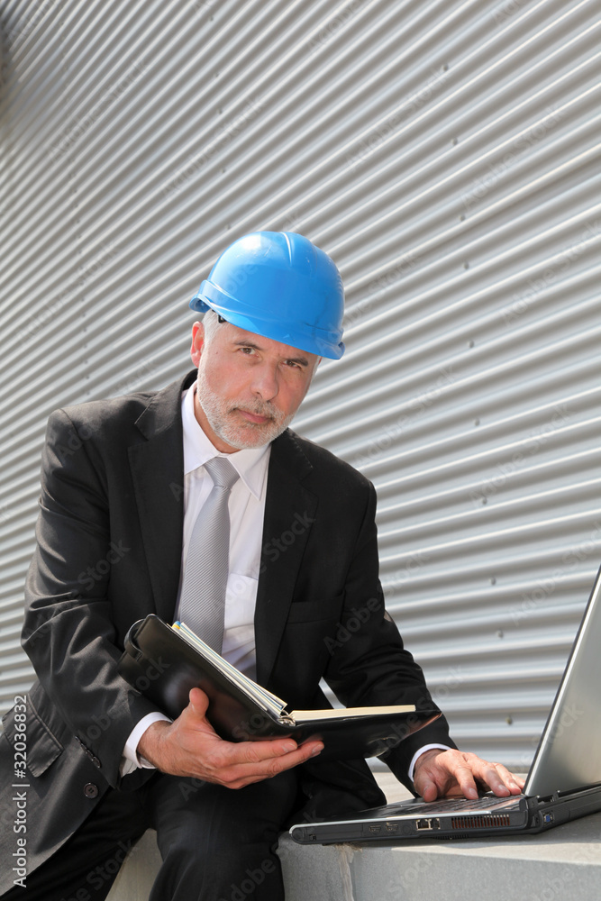 Site manager checking planning on computer Site manager checking planning on computer
