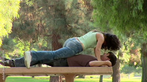 Young couple being affectionate on a park bench