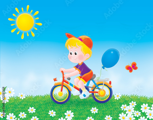 Boy bicycles on the grass