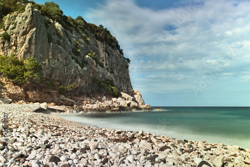 high cliffs and rocky beach white pebbles © kikkerdirk