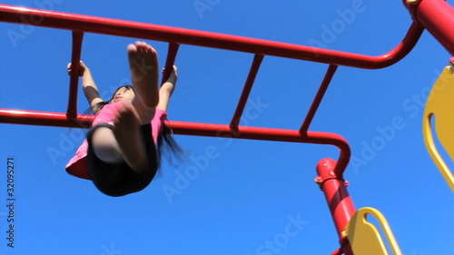 Asian Girl On Monkey Bars At Playground