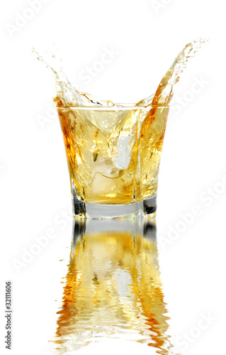 Splash of whiskey with water reflection.