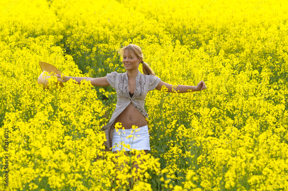 Fototapeta premium Junge Frau im Rapsfeld