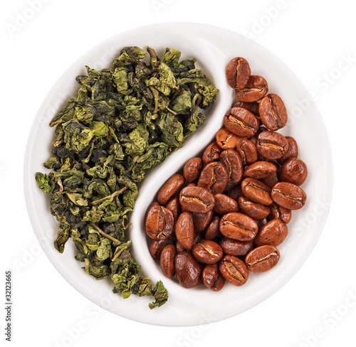 Green leaf tea versus coffee beans in Yin Yang shaped plate, iso