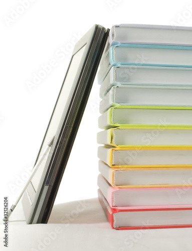 Stack of colorful books and ebook reader on the white background