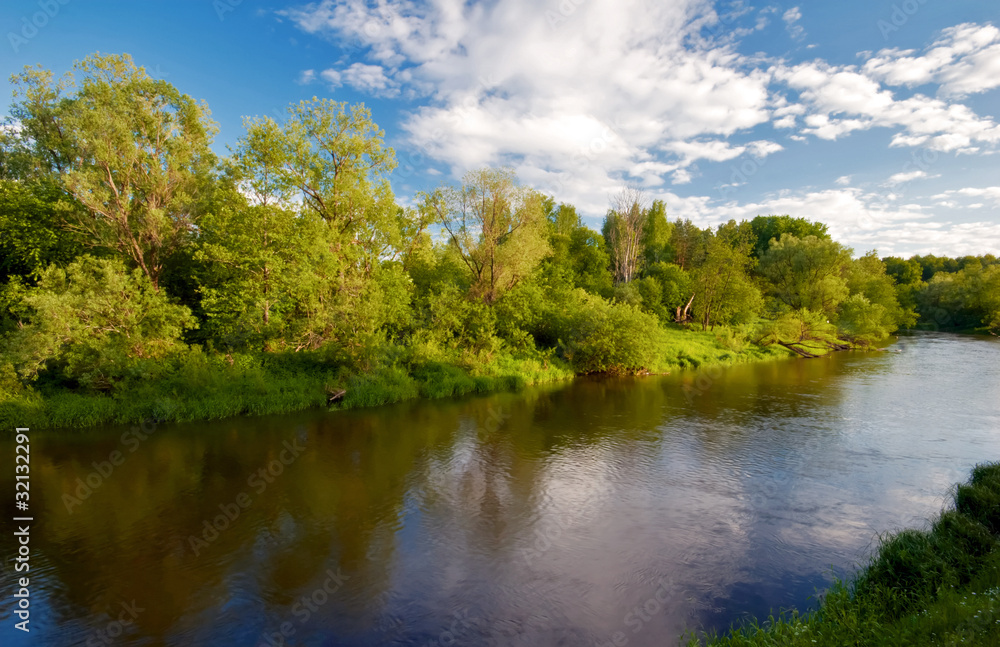 Green field with river under blue sky Green field with river under blue sky